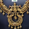 Aimpon Haram, a gold-toned metal necklace featuring a seated figure flanked by two peacocks and seven dangling ribbed sphere beads with red and clear stones