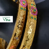 Impon Bangles, two gold-toned, engraved bangles featuring floral motifs set with pink and green stones and single clear stones near their ends