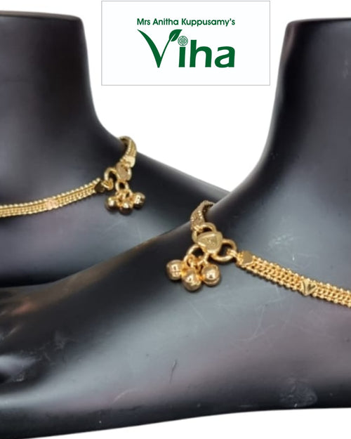 Impon Anklets, gold-toned chain anklets with bell charms worn on mannequin feet