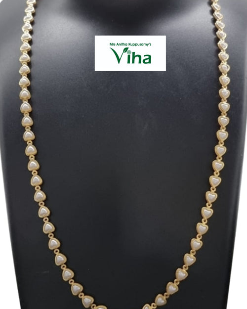 Impon Pearl Chain, a long gold-toned necklace with heart-shaped pearl accents worn on a mannequin