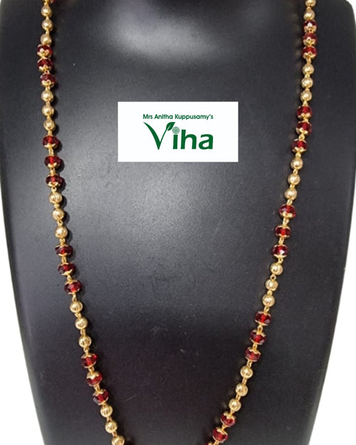 Impon Chain, necklace of gold beads and dark red faceted beads on a black display bust
