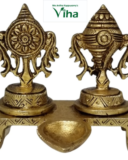 Sangu chakra manai deepam, two engraved pedestals on a footed plinth with a leaf-shaped oil bowl in front