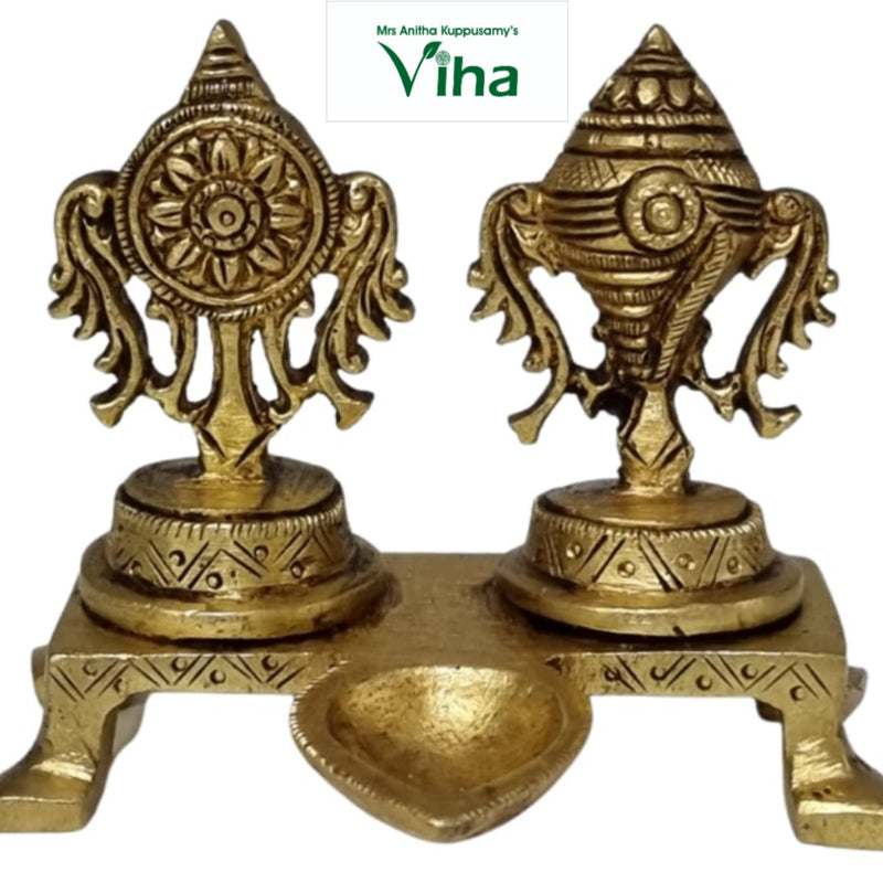 Sangu chakra manai deepam, two engraved pedestals on a footed plinth with a leaf-shaped oil bowl in front