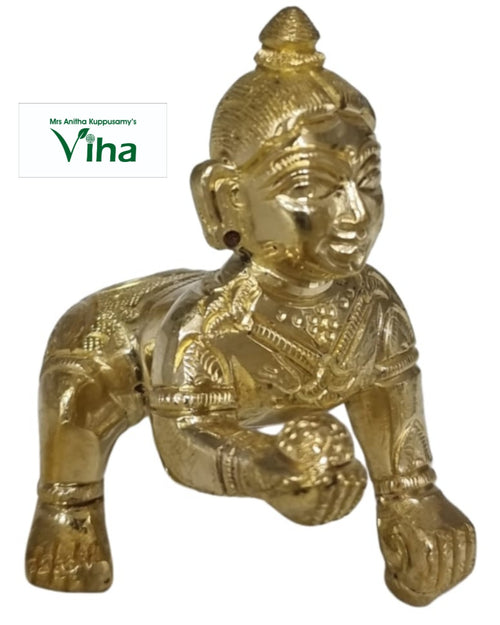 Laddu Gopal in brass, crawling child figure with a topknot and one hand extended forward