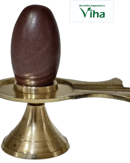 Narmadeshwar Shivling With Brass Stand, a brown oval stone rests inside a gold-toned metal stand with a flared base and a spouted circular tray