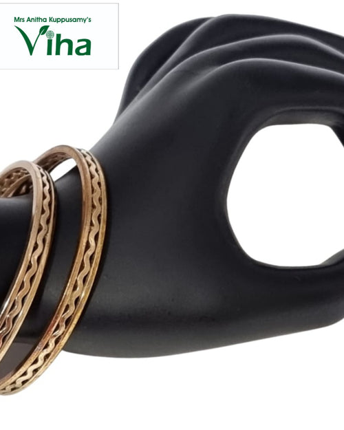 Impon Bangles, two gold-toned metal bangles with wavy engraved patterns on a black mannequin hand