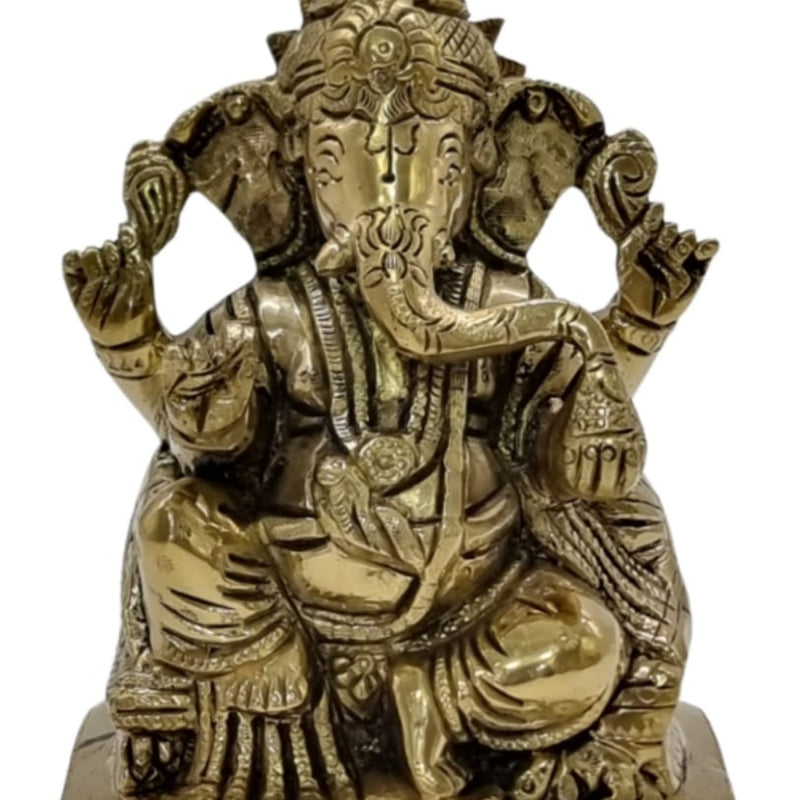 Idampuri Ganesha in brass, seated four-armed figure with the trunk turned to the left