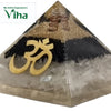 Black & White Vastu Pyramid with EMF Protection, a pyramid with clear base containing white shards, black middle layer, gold-toned symbol and coils