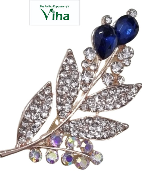 Saree Pin, a rose gold-toned floral brooch featuring eight clear stone-paved leaves, two dark blue teardrop stones, and eleven iridescent round stones