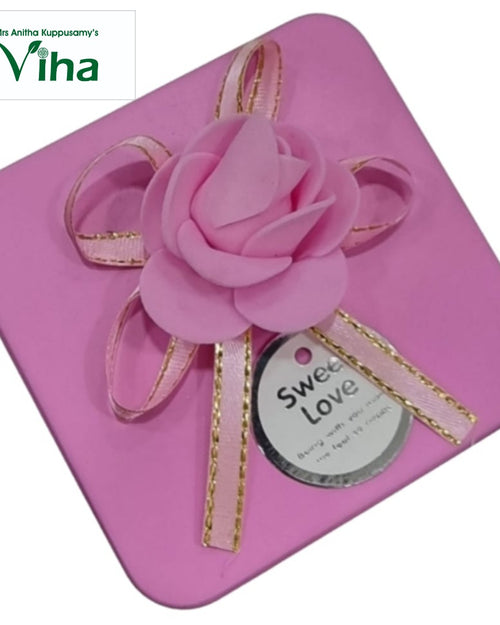 Metal Storage Box, a pink square box featuring a large pink rose and a pink ribbon with metallic-toned edges atop its lid