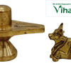 Shivling with Nandhi, two gold-toned metallic figurines, one standing pillar-like object and one lying bovine animal figure, both with a polished finish