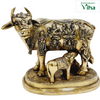 Kamadhenu cow and calf in brass, cow with rows of small deity figures across the flank and a calf beneath, on an oval base