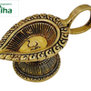 Om vilakku in antique brass, paisley oil bowl with a raised Om and a scrolled rim, loop handle behind