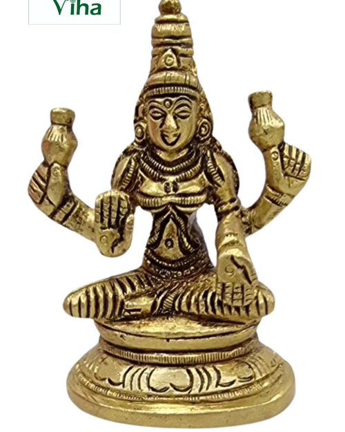 Mahalakshmi in brass, four-armed figure seated on a plain round drum pedestal with a tall pointed crown