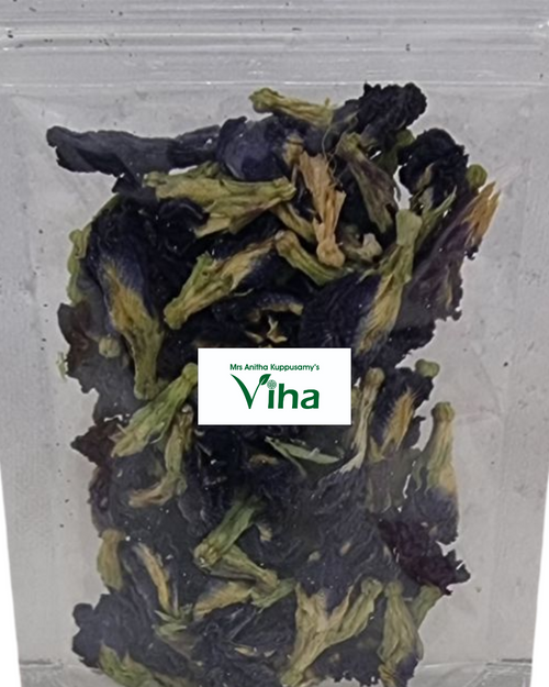 Sangu Poo / Blue Pea, a clear plastic pouch filled with dried, crumpled blue-purple flowers having green-yellow sepals and stems