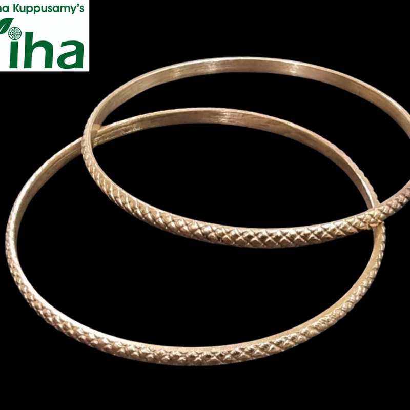 Impon Baby Bangles, two gold-toned metal bangles with textured crosshatch patterns and smooth inner bands against a black background