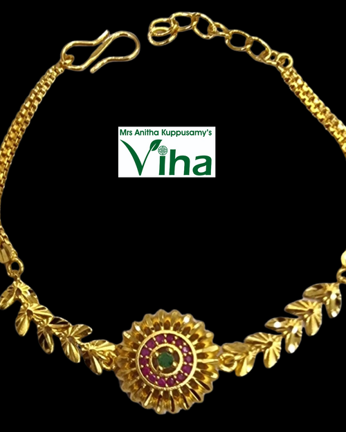Impon Bracelet, a gold-toned metal chain featuring leaf links and a round center piece set with one green and twelve red stones