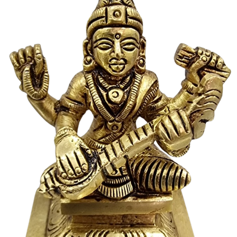 Saraswathi in brass, four-armed figure seated on a square stepped base with a tall crown and arms raised