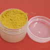 Swamy Thilagam Powder, one small round translucent jar with a yellow powder and an open lid beside it