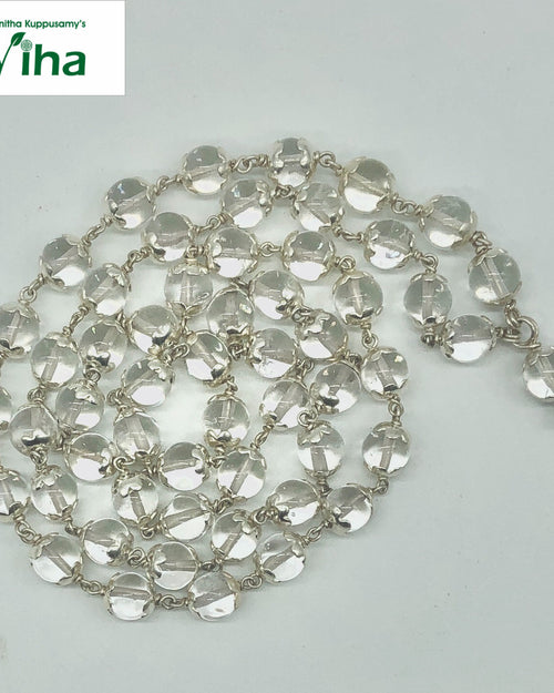 Sphatik Mala With Silver Cappings, a coiled necklace featuring numerous transparent round beads held by metallic links on white