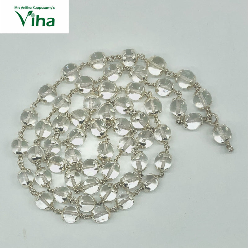 Sphatik Mala With Silver Cappings, a coiled necklace featuring numerous transparent round beads held by metallic links on white