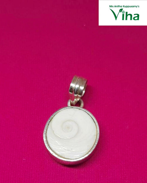 Silver Gomathi Chakra Pendant, a round silver-toned pendant with a white shell inlay showing a spiral pattern, on a magenta background