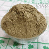 Adult Herbal Bath Powder, a small glass bowl filled with mounded brown powder sits on a white fabric patterned with green floral motifs