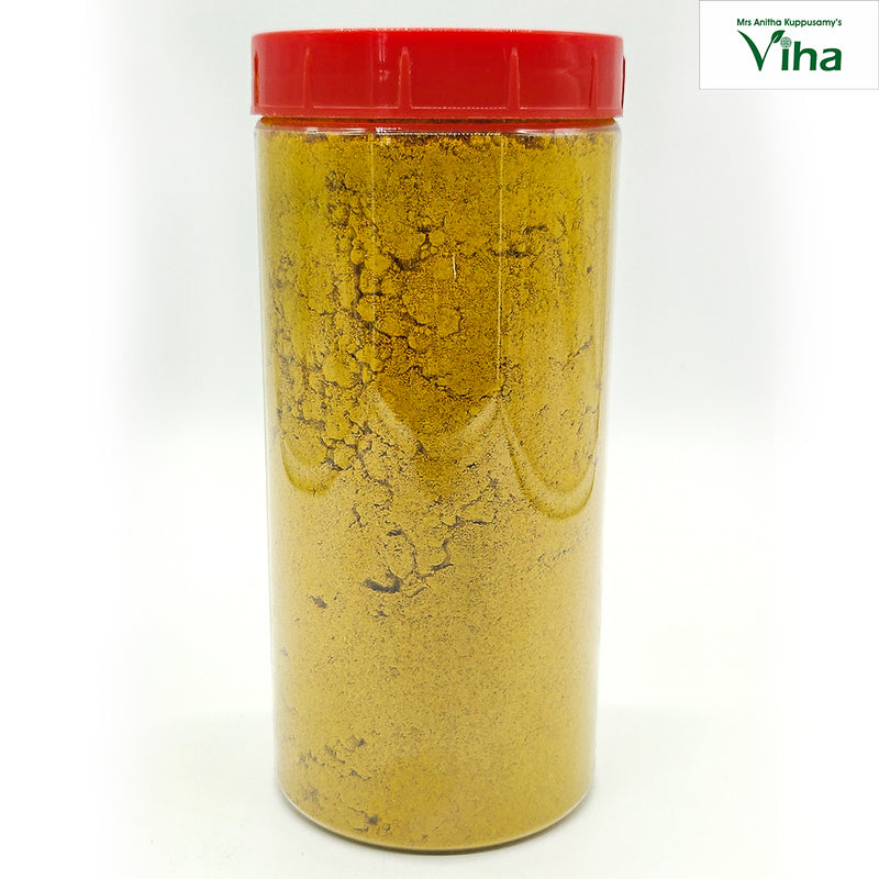 Drishti Rock Salt Mixture in a tall clear jar of yellow powder with a red lid