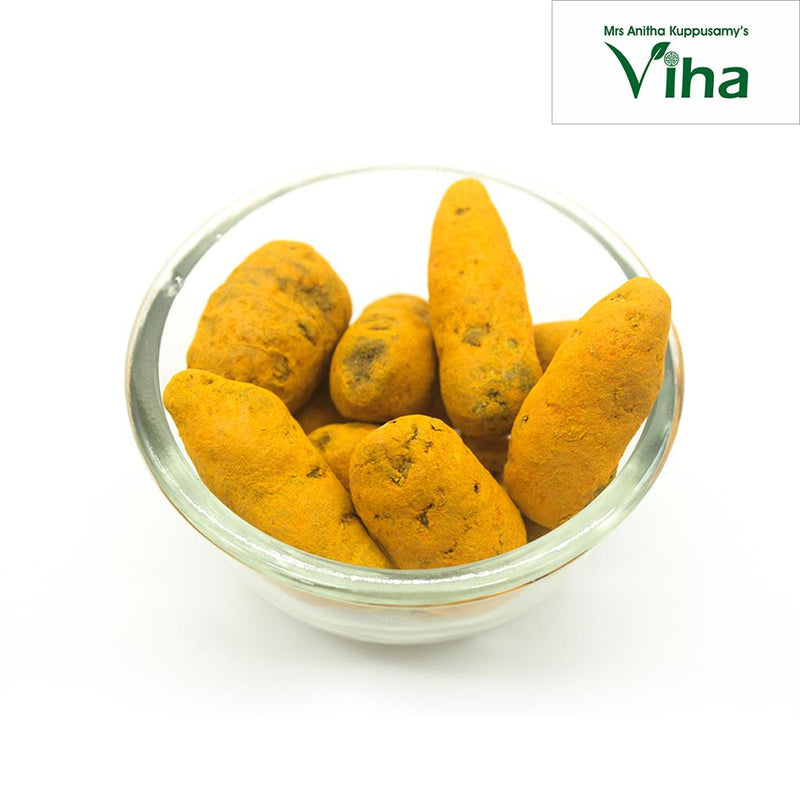 Poosu Manjal (Turmeric), nine rough yellow-orange turmeric roots piled inside a clear round glass bowl