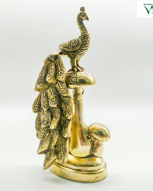 Brass peacock, standing bird with a large fan of layered tail feathers behind, on a rounded base