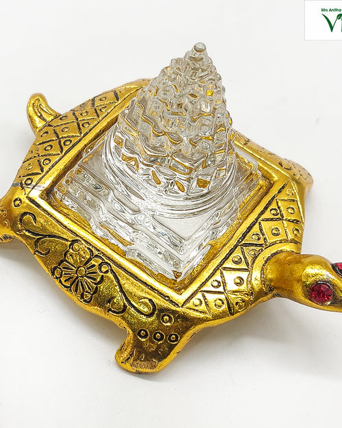 Tortoise Sphatik Maha Meru, golden tortoise with engraved patterns, red gemstone eyes, and a transparent stepped crystal pyramid on its back