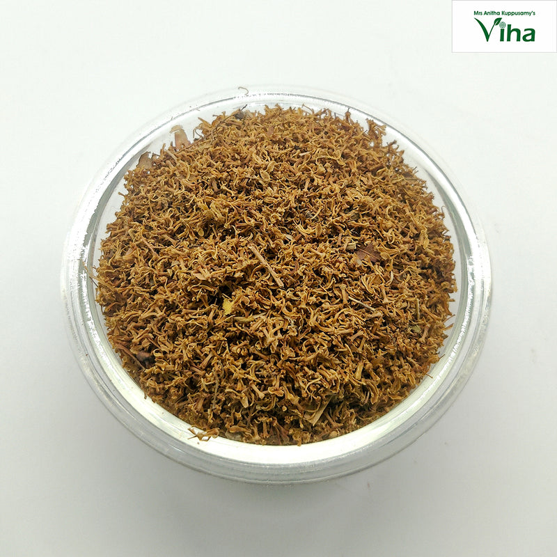 Veppam Poo, a clear round bowl filled with brown dried flower fragments and tiny twigs viewed from above against a white background