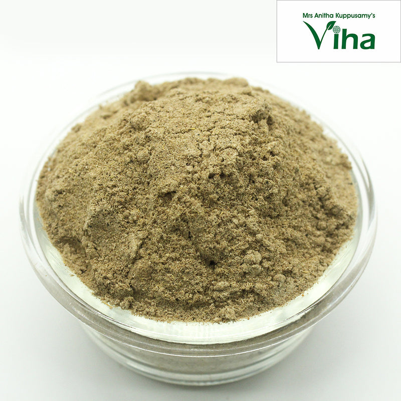 Vettiver Powder, a mound of fine brownish-grey fibrous powder in a transparent round glass bowl against a white background